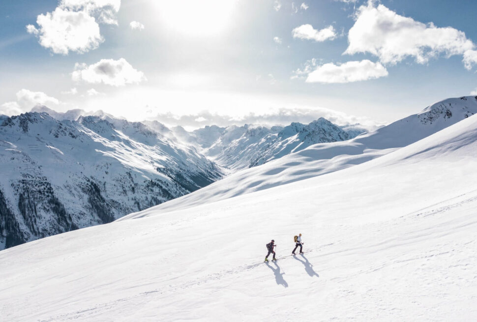 People hiking on a snow-covered mountain trail.