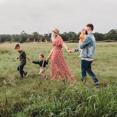 Family walking together in a grassy field, symbolizing Child-Friendly travel.