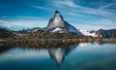 Reflection of the iconic Matterhorn mountain on the still waters of Lake Stellisee, surrounded by alpine scenery.