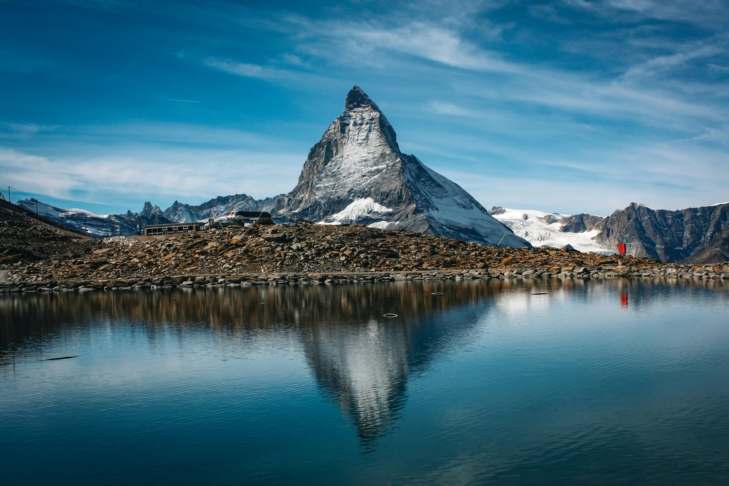 Reflection of the iconic Matterhorn mountain on the still waters of Lake Stellisee, surrounded by alpine scenery.