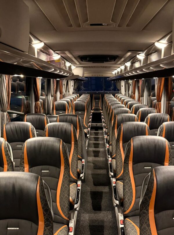 Interior of a modern bus, showcasing comfortable, spacious seats, large windows, air conditioning, and a sleek, clean design, perfect for sightseeing tours.