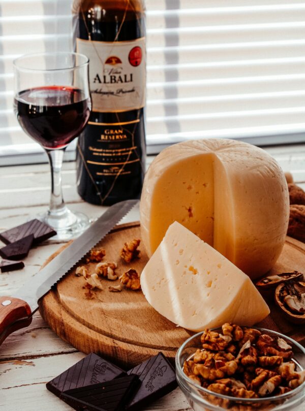 Visitors enjoying a wine tasting experience at a vineyard, surrounded by wine barrels and lush grapevines.