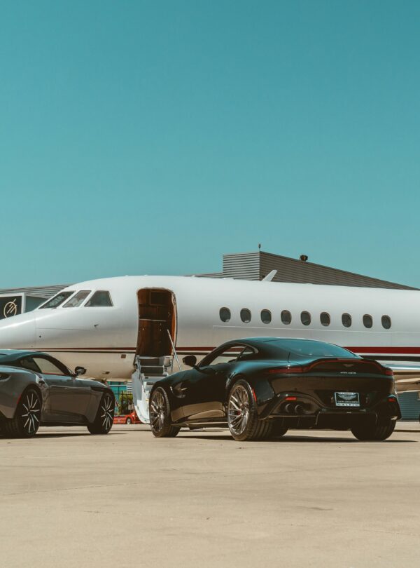 A private jet parked beside two luxurious cars, highlighting a lifestyle of luxury and exclusivity.